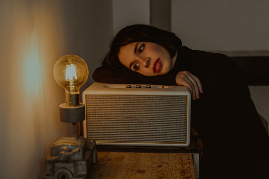 Tranquil woman looking at light bulb in vintage room