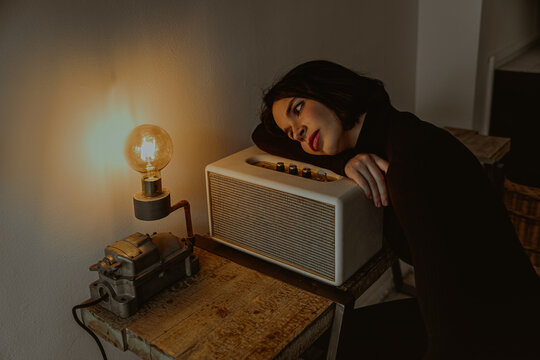 Tranquil woman looking at light bulb in vintage room