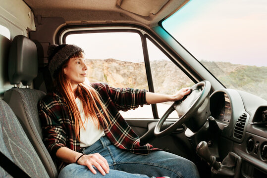 Woman sitting in van in mountains