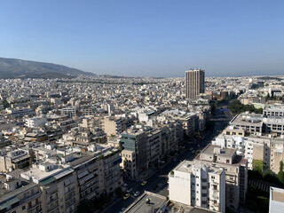 view of Athens Greece from up high on a clear blue day with buildings, mountain and city streets