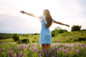 Portrait of beautiful woman in amazing in a blooming field. Nature, vacation, relax and lifestyle. Summer landscape.