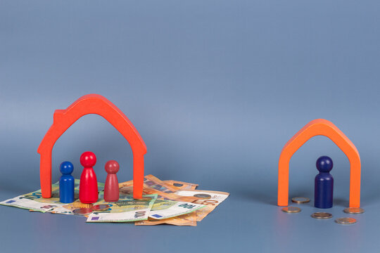 Divorce, conflict between parents, children custody, property division. Wooden houses, miniature figures of parents and children on gray background