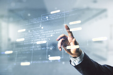 Double exposure of programmer's hand working with abstract creative programming illustration on blurred office background, big data and blockchain concept