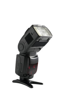 A professional, expensive external remote photography digital travel flash standing on a table tripod, cut out on white background with copyspace