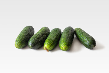 Few green cucumbers with pimples on a light background