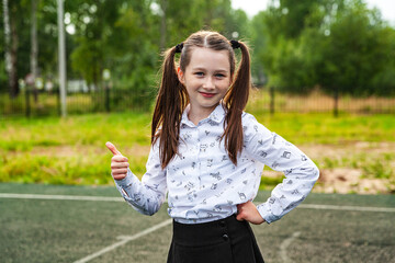 Schoolgirl in white blouse and black skirt , long hair is taken in tails, school, education,...
