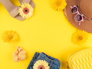 Summer fashion outfit frame background with straw hat, shoes, sunglasses, handbag, flowers on yellow