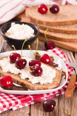 Rye bread with cottage cheese and cherries.