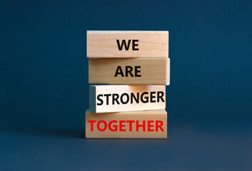 Stronger together symbol. Wooden block with words 'we are stronger together'. Beautiful grey background. Businessman hand. Copy space. Business, motivational and we are stronger together concept.