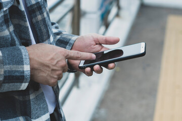 teen boy using smartphone device for online network technology internet;  man use mobile in public park