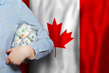 American Dollar banknotes on national Canadian flag with waving background. Canada, financial theme.