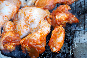 chicken marinated in tomato sauce with paprika lies on the grill grid top view. outdoor food