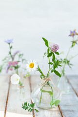 Concept of pure natural organic herbal and flower ingredients in cosmetic production. Camomile, lavender essential oils for gentle face and body care. Aromatherapy. Wooden background, copy space