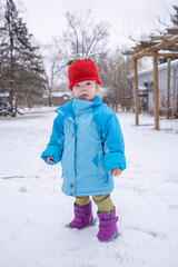 Toddler girl portrait in the snow in her backyard on a winter day