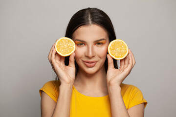 Happy smiling woman brunette with yellow lemon fruits on white background