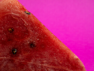 Ripe red watermelon on a pink background.