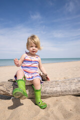 Toddler at Indiana Dunes National Park sitting on driftwood 