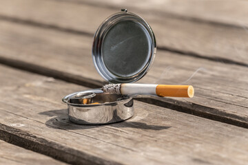 A cigarette on a portable ashtray