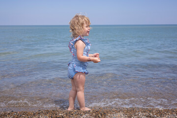 Little girl playing on the beach at Indiana Dunes National Park along the shoreline.