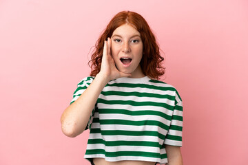 Teenager redhead girl over isolated pink background with surprise and shocked facial expression