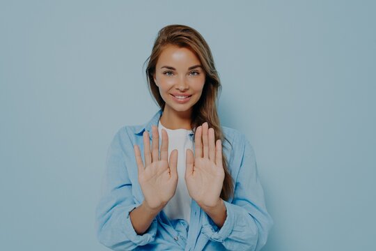 Young Beautiful Woman In Casual Clothes Standing And Holding Both Hands Out