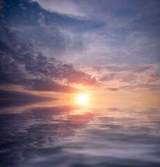 Naklejka na ściany i meble Dramatic sky at sunset on a summer day over the ocean.