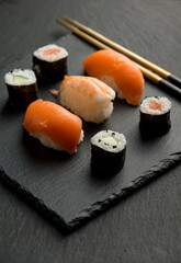 sushi with chopstick over black stone
