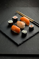 sushi with chopstick over black stone