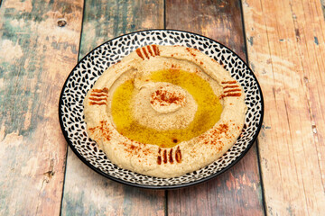 Chickpea hummus volcano cooked with puddle of Spanish olive oil and scratches stuffed with paprika of peppers