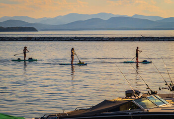 Three people on paddle boards enjoying the Burlington Waterfront on Lake Champlain
