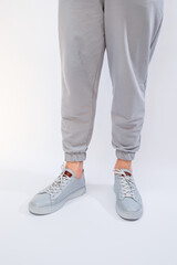 Men's sneakers on a very gray day of natural leather, men's legs shoes in gray leather shoes