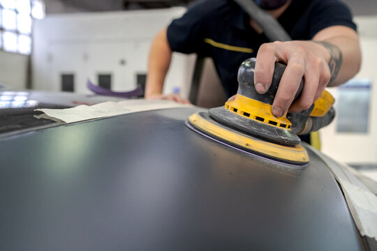 Crop man buffing car in service