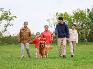 Happy family of five and pet dog walking in the park