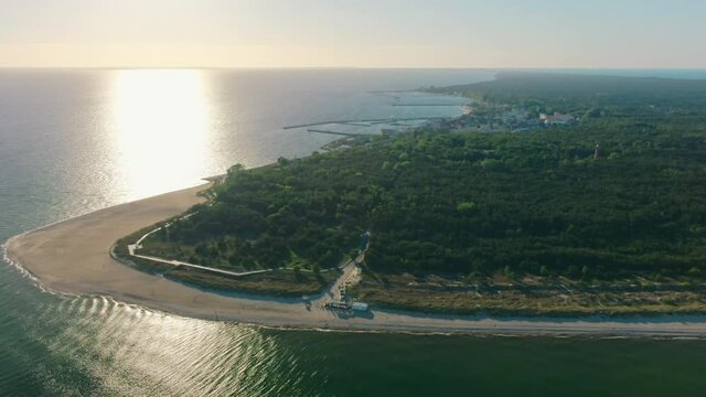 Epic Aerial View to Scenic Sunset above Hel Peninsula in Baltic Sea in Poland in Summer with Beach and Forest. Travel and Holiday Destination in Europe. 4K Nature Drone Zoom in Shot