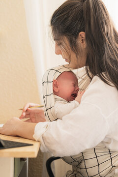 Mom with crying newborn baby at home
