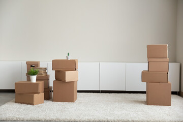 Picture of empty cozy room with cardboard boxes packages in new rent house or apartment. Carton parcels on moving or relocation day settle at home. Real estate, realty, rental concept.