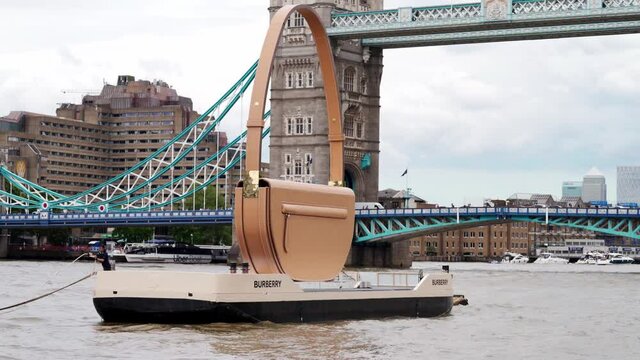 Burberry Olympia bag floating down the Thames River with the Tower Bridge in the background