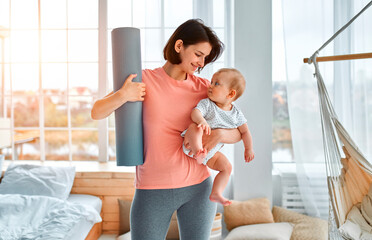 A sports mother is engaged with the child in fitness and yoga at home. The concept of sports,...