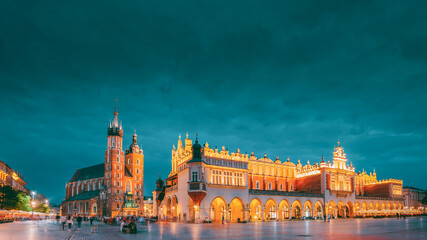 Krakow, Poland. Evening Night View Of St. Mary's Basilica And Cloth Hall Building. Famous Old Landmark Church Of Our Lady Assumed Into Heaven. UNESCO World Heritage Site