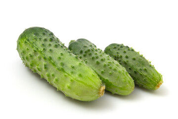 Three green gherkin cucumbers isolated on white background.