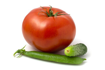A large tomato, a small cucumber and a pod of young green peas. Fresh vegetables isolated on white background.