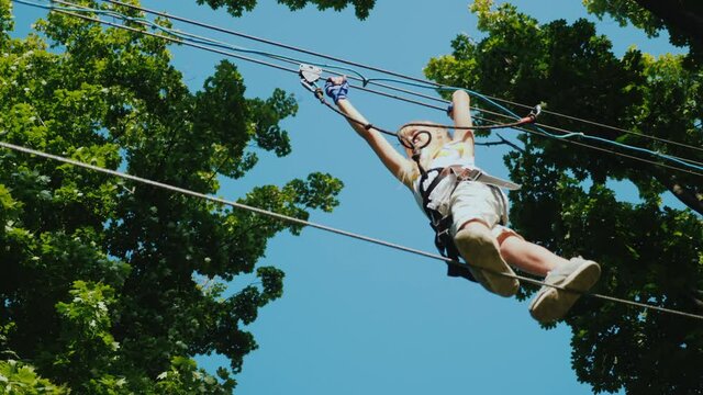A brave child takes steps on a staggered cable at a height. Overcome fear concept