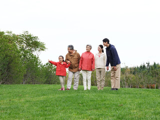 Naklejka na ściany i meble Happy family of five looking at the scenery in the park