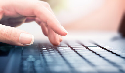 hand is typing text on the keyboard close-up