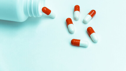 capsules with medicine and an empty bottle on a white background.