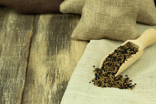 Cumin and black sesame seeds in a wooden spoon