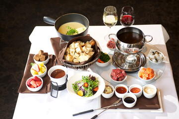 Fondue plate at a restaurant.  Cheese, traditional oil, and chocolate fondue