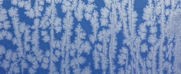 Ice crystals on window with blue background