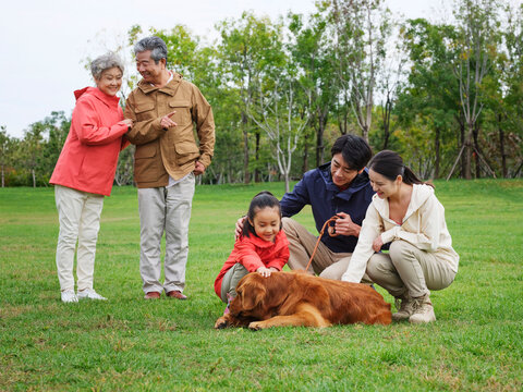 Happy family of five and pet dog playing in the park