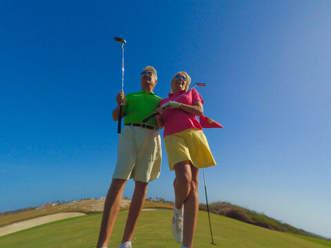 Close-up Of Active Senior Couple Playing Golf 